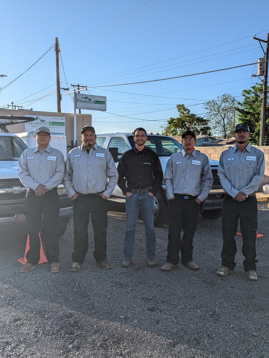 The Paramount Roofing crew standing in front of their company trucks