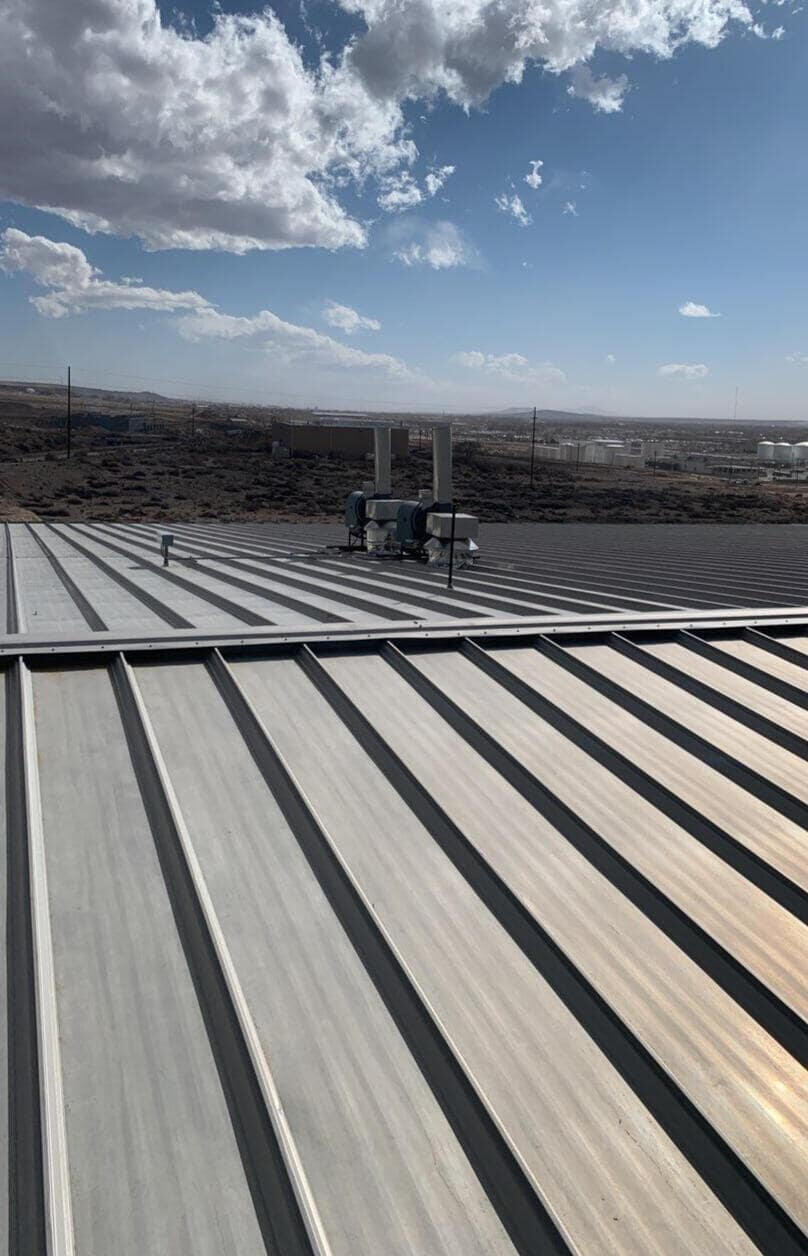A well-maintained commercial metal roof in Albuquerque, New Mexico. The roof features multiple penetrations and is in good condition.