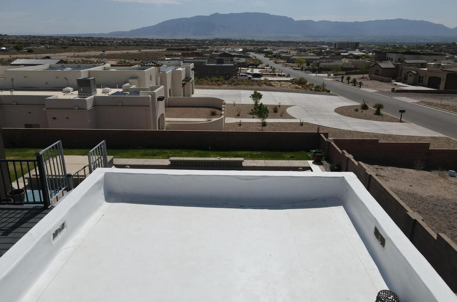 New white TPO (Thermoplastic Polyolefin) roofing material installed on a residential roof in Rio Rancho, New Mexico.
