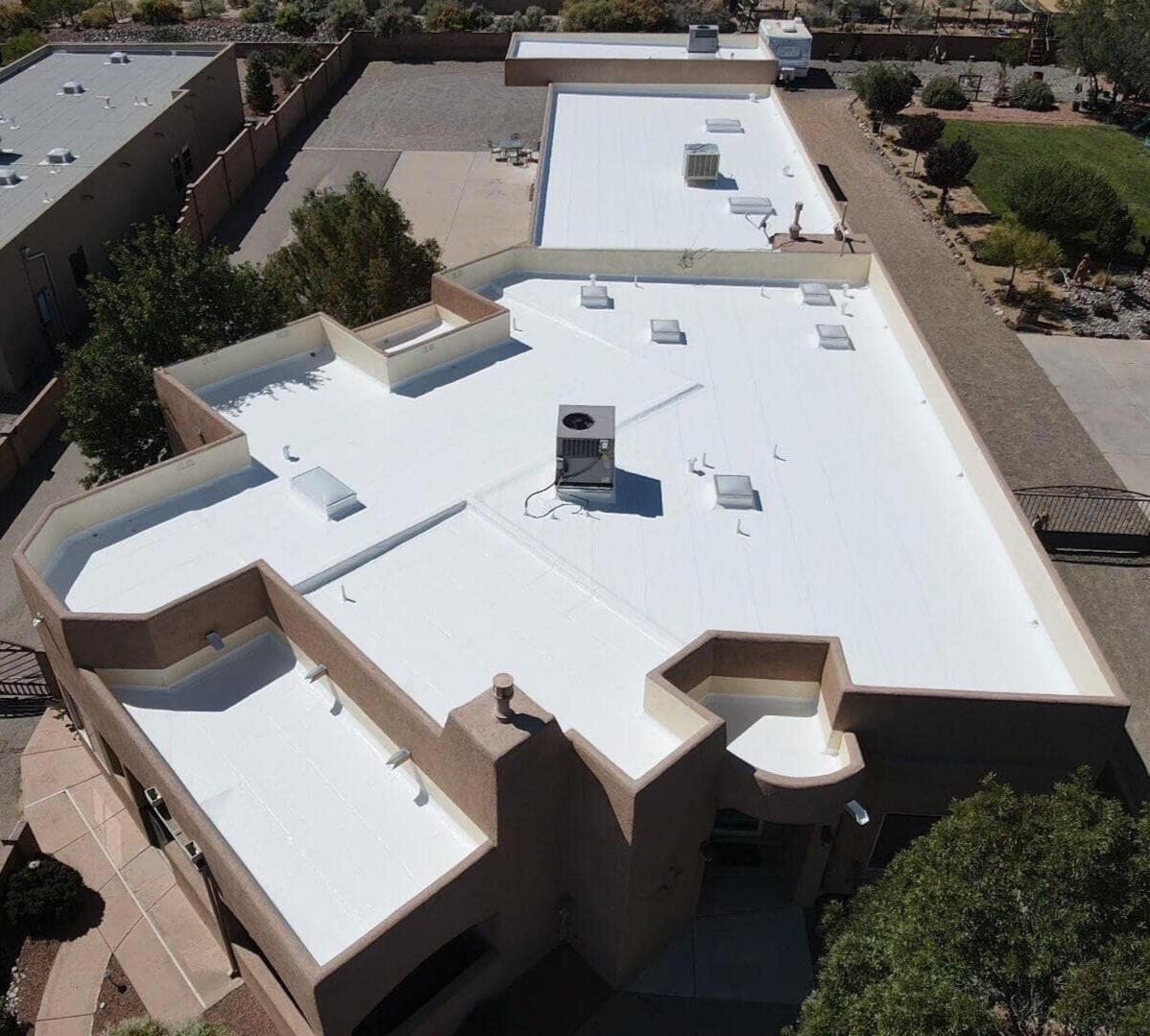 Residential flat roof in Albuquerque, New Mexico, recently outfitted with a white TPO (Thermoplastic Polyolefin) membrane for enhanced protection and energy efficiency.